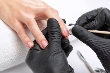 Manikürcü, kuaförde tırnak etlerini söker. Profesyonel el bakımı..