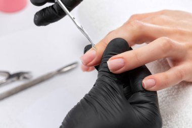 Manikürcü, kuaförde tırnak etlerini söker. Profesyonel el bakımı..