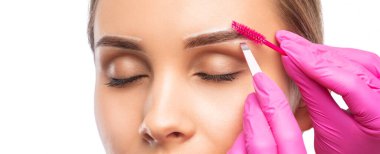 Makyöz bir güzellik salonunda kaşlarını tarar ve koparır. Profesyonel makyaj ve estetik cilt bakımı.