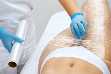 Masör güzellik salonunda tüm vücudunu kaplayan kozmetik bir işlem yapıyor. Güzellik salonunda spa tedavisi