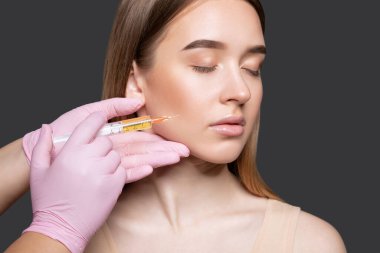 Kozmetik uzmanı güzellik salonunda güzel bir kadının terapisini yapıyor. Kozmetoloji kavramı.