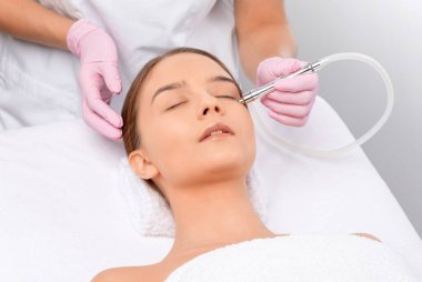 Sivilcelere ve siyah noktalara karşı yüzde prosedür mikro dermabrüksiyon. Güzellik salonunda kadın kozmetolojisi.