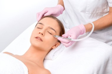 Sivilcelere ve siyah noktalara karşı yüzde prosedür mikro dermabrüksiyon. Güzellik salonunda kadın kozmetolojisi.