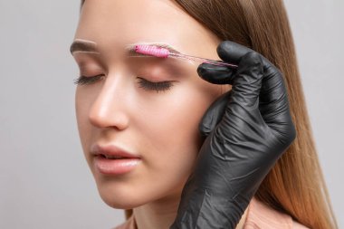 Makyaj sanatçısı kaşların uzun süreli stilini yapar ve kaşlarını boyar. Kaş kaplaması. Profesyonel makyaj ve yüz bakımı..