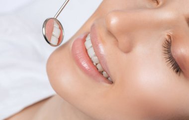 Diş hekimi, dişçi kliniğinde genç ve güzel bir kadının dişlerini tedavi eder. Diş dolgusu.