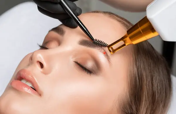 stock image Removal of permanent makeup on the eyebrows.Carbon face peeling in a beauty salon. Hardware cosmetology treatment.