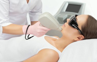  Bir kadının vücudunda epilasyon tüy çıkarma prosedürü. Güzellik uzmanı bir güzellik salonunda lazer gençleştirme yapıyor. İstenmeyen vücut kılları alınıyor. Donanım ipl kozmetolojisi