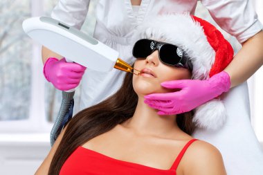 Bir kadının dudaklarındaki kalıcı makyajın kaldırılması. Güzellik salonunda soyulan karbon surat. Donanım kozmetoloji tedavisi.