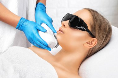 Bir kadının yüzündeki epilasyon tüy çıkarma prosedürü. Güzellik uzmanı bir güzellik salonunda lazer gençleştirme yapıyor. İstenmeyen vücut kılları alınıyor. Donanım ipl kozmetolojisi