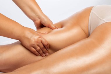 Masör anti-selülit masaj yapar bacaklara, kalçalara, kalçalara ve kalçalara masaj yapar. Aşırı kilolu tedavi, vücut heykeli. Kozmetik ve masaj konsepti..