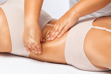 Masör anti-selülit masaj yapar bacaklara, kalçalara, kalçalara ve kalçalara masaj yapar. Aşırı kilolu tedavi, vücut heykeli. Kozmetik ve masaj konsepti..