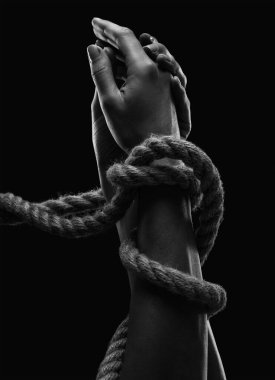 Hands of a man with hands tied with ropes. Photo black and white clipart