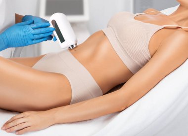  Epilasyon, kadın vücudunda kıl çıkarma prosedürü. Güzellik uzmanı bir güzellik salonunda lazer gençleştirme yapıyor. İstenmeyen vücut kılları alınıyor. Donanım ipl kozmetolojisi