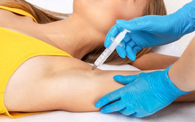 Doktor koltukaltı bölgesinde hiperhidrosite karşı botulinyum toksini enjekte ediyor. Kadın kozmetolojisi kavramı.