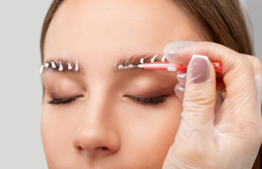 Makyaj sanatçısı uzun süreli kaş stili yapar ve kaşlarını boyar. Kaş kaplaması. Profesyonel makyaj ve yüz bakımı..