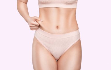 Kız karın derisini yüzüyor, vücut yağını gösteriyor. Aşırı kilonun tedavisi ve bertaraf edilmesi, deri altı yağ birikimi..