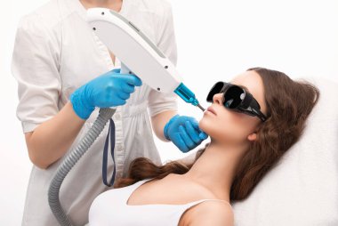 Bir kadının kaşlarındaki kalıcı makyajın kaldırılması. Güzellik salonunda soyulan karbon surat. Donanım kozmetoloji tedavisi.