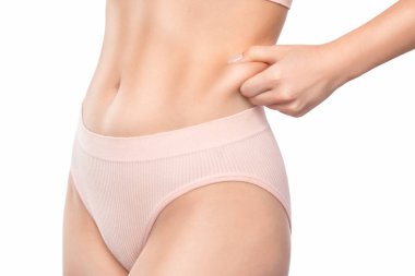 Kız karın derisini yüzüyor, vücut yağını gösteriyor. Aşırı kilonun tedavisi ve bertaraf edilmesi, deri altı yağ birikimi..