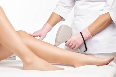 Bir kadının vücudunda epilasyon tüy çıkarma prosedürü. Güzellik uzmanı bir güzellik salonunda lazer gençleştirme yapıyor. İstenmeyen vücut kılları alınıyor. Donanım ipl kozmetolojisi