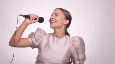 Güzel, neşeli bir kız en sevdiği şarkıyı bir karaoke barda mikrofona söylüyor..