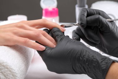 Manikürcü, kuaförde tırnak etlerini söker. Profesyonel el bakımı..