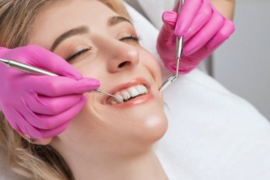 Diş hekimi, dişçi kliniğinde genç ve güzel bir kadının dişlerini tedavi eder. Diş dolgusu.