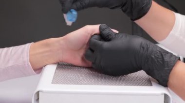 Manikür testeresinin ustası güzellik salonundaki tırnak uzatma işlemi sırasında tırnak şekli takıyor. Eller için profesyonel bakım.