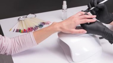 Güzellik salonunda jöle ojeli tırnaklar. Eller için profesyonel bakım.