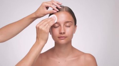 Makyöz makyaj yapmadan önce deriyi mikiler suyuyla temizler. Kozmetoloji ve profesyonel cilt bakımı.