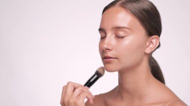 Makyaj sanatçısı güzel bir kızın yüzüne temelini atar. Profesyonel makyaj konsepti