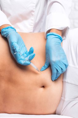 Güzellik uzmanı bir adamın karnında yağ yakmak için lipolitik enjeksiyon yapar. Güzellik salonunda erkek estetiği..