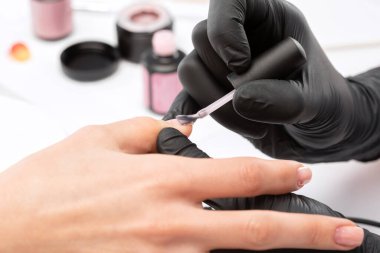 Manikürcü, kuaförde tırnak etlerini söker. Profesyonel el bakımı..
