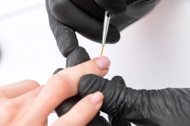 Manikürcü, kuaförde tırnak etlerini söker. Profesyonel el bakımı..