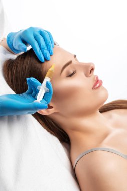Kozmetik uzmanı güzel bir kadının yüzüne kırışıklık önleyici iğneler yapıyor. Güzellik salonunda kadın estetiği..