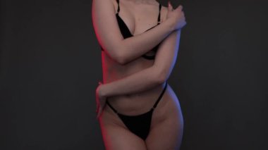 Siyah arka planda siyah seksi iç çamaşırları olan güzel bir kız vücudu. Seksi vücut, çıplaklığı kapat