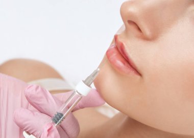 Kozmetik uzmanı güzel bir kadının yüzüne dudak büyütme, kırışıklık önleyici iğneler yapıyor. Güzellik salonunda kadın estetiği..