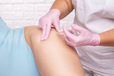 Estetik kozmetik doktoru kadın karnında ve vücudunda yağ yakmak için lipolitik enjeksiyon yapar. Güzellik salonunda kadın estetiği..