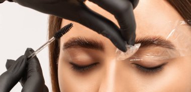 Makyaj sanatçısı uzun süreli kaş stili yapar ve kaşlarını boyar. Kaş kaplaması. Profesyonel makyaj ve yüz bakımı..