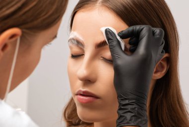 Makyaj sanatçısı uzun süreli kaş stili yapar ve kaşlarını boyar. Kaş kaplaması. Profesyonel makyaj ve yüz bakımı..