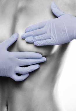 Çıplak kadın göğsü yakın plan. Beyaz arka planda çıplak gövdeli seksi zayıf bir kadın. Kız, fok balığı olup olmadığını anlamak için meme bezlerini inceliyor..