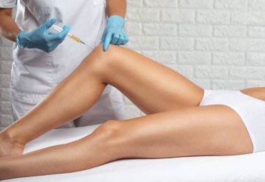 Yaralanmadan sonra bir hastanın dizinde kök hücre tedavisi yapan bir doktor. Diz ağrısını trombosit zengini plazma enjeksiyonuyla tedavi ediyorum. Eklem iltihabı ve osteoartrit tedavisi. Tıbbi ve kozmetik konsepti..