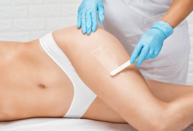 Bir kadının vücudunda epilasyon tüy çıkarma prosedürü. Güzellik uzmanı bir güzellik salonunda lazer gençleştirme yapıyor. İstenmeyen vücut kılları alınıyor. Donanım ipl kozmetolojisi