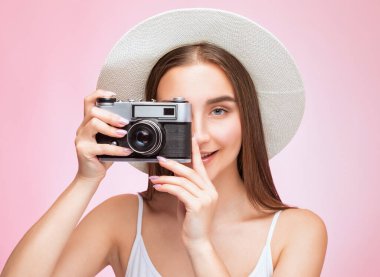 Güzel, çekici bir kadın fotoğrafçının elinde klasik bir kamera var. Turizm ve seyahat kavramı.