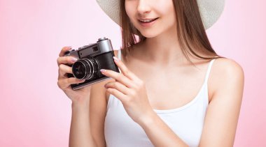 Güzel, çekici bir kadın fotoğrafçının elinde klasik bir kamera var. Turizm ve seyahat kavramı.