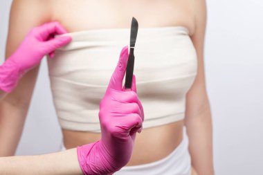 Bir kadının göğsündeki bandaj. Göğüs büyütme. Silikon göğüs.