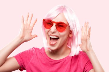 Pembe peruklu, pembe tişörtlü ve pembe arka planda gözlüklü güzel bir kız..