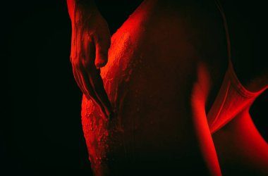 Bir kız balla anti-selülit masajı yapar. Siyah arka planda güzel seksi bir kadın. Bal damlaları kalçalarına akıyor.