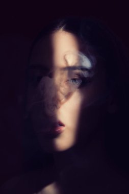 Güzel makyajlı, dolgun dudaklı bir kadın sigarasını yakın plan içer..