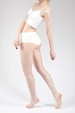 Beyaz kozmetoloji odasında beyaz iç çamaşırlı ince esmer bir kadın. Sağlıklı yaşam tarzı, spor ve diyet.