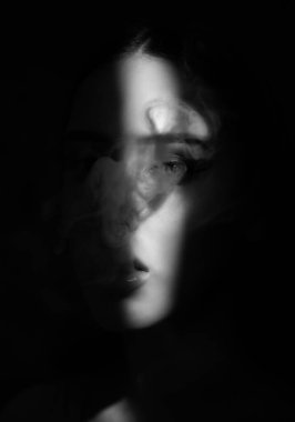 Güzel makyajlı, dolgun dudaklı bir kadın sigarasını yakın plan içer..